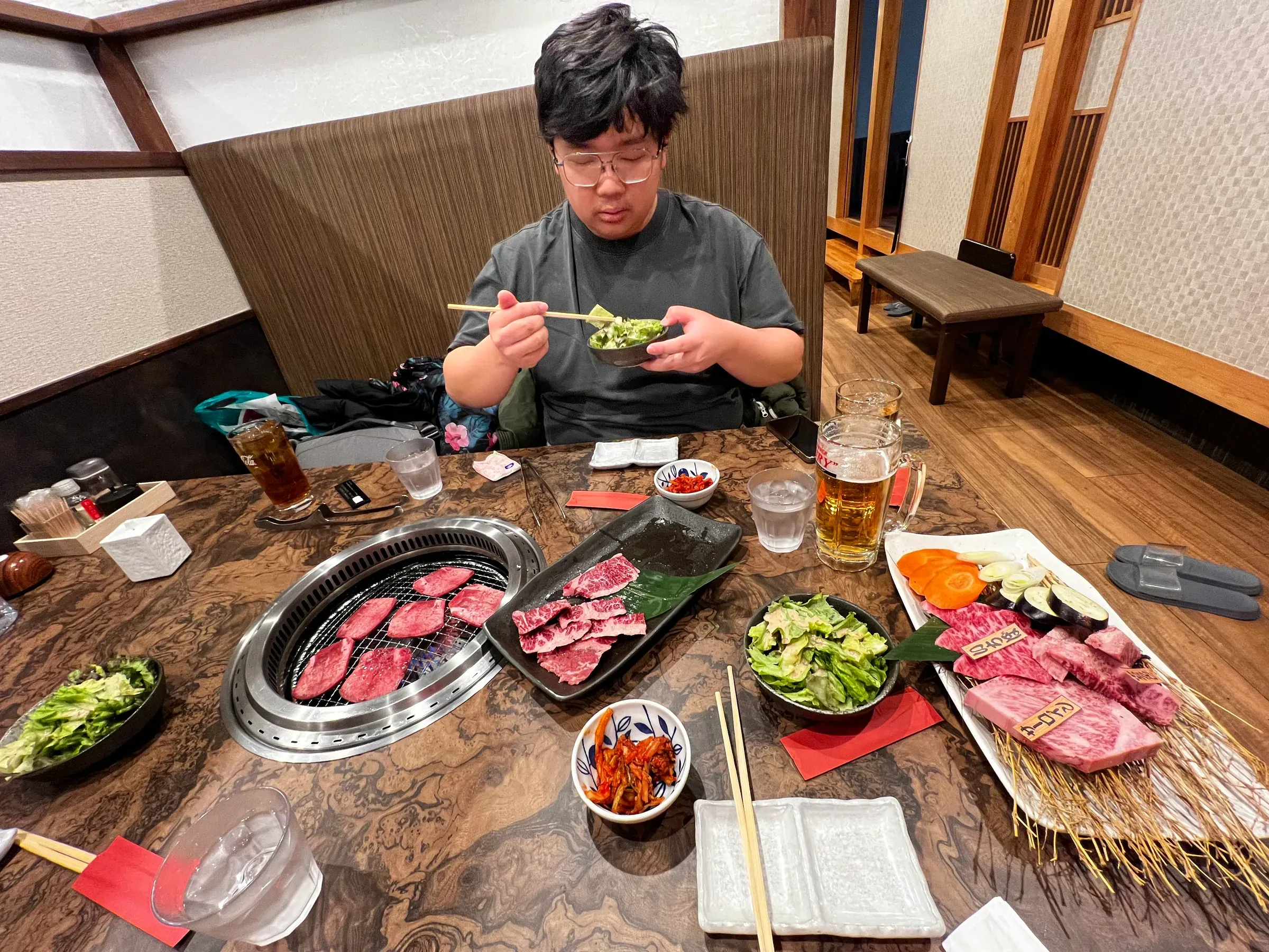 桌上摆满了和牛和蔬菜，炭火正旺